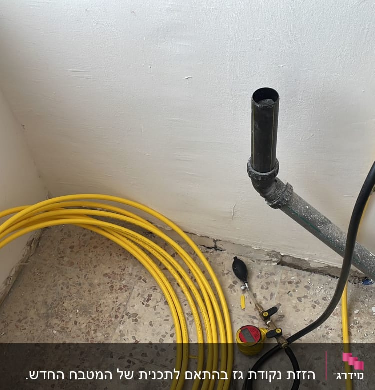 צינור גז צהוב מגולגל ליד קיר עם חיבורים